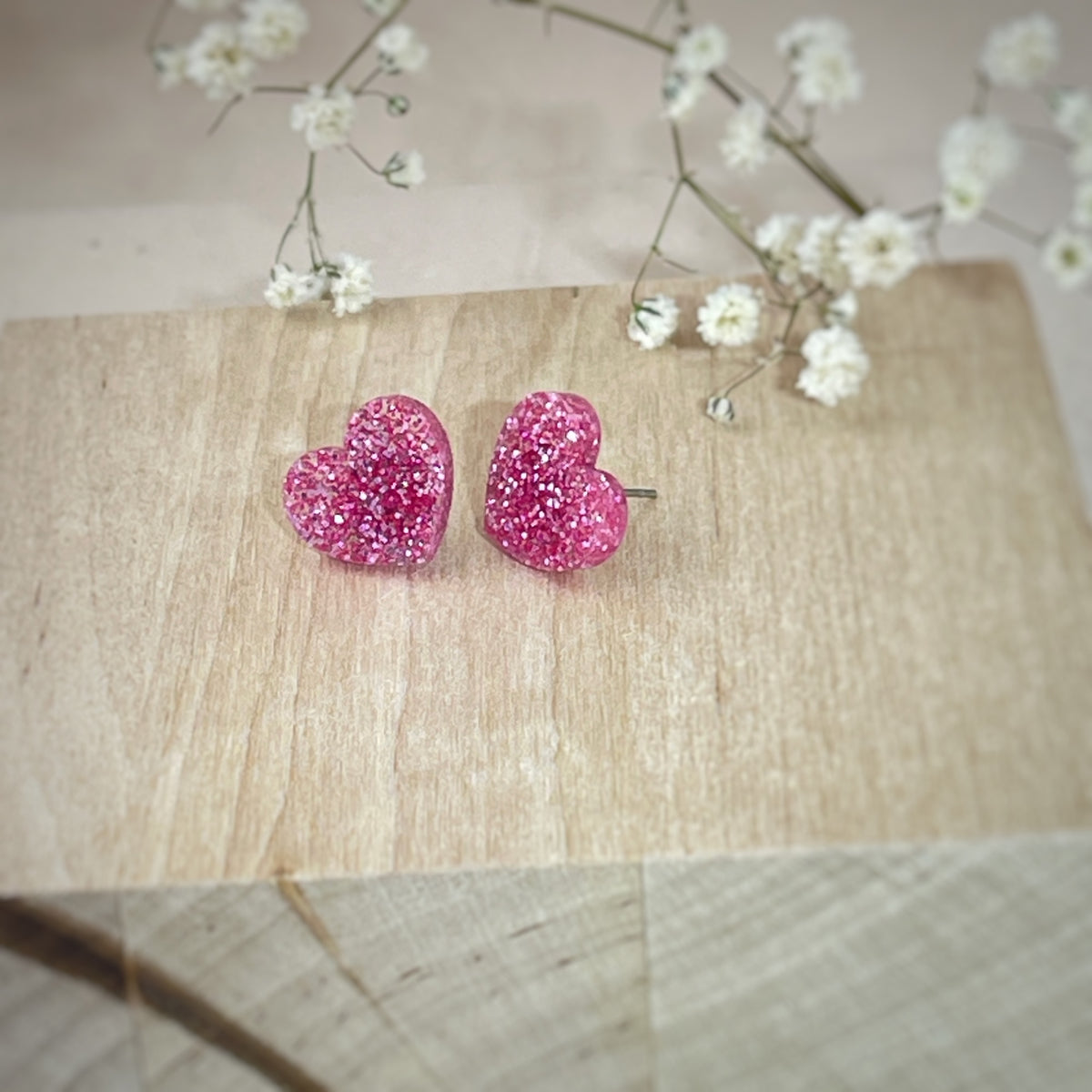 Vaaleanpunaiset glitterisydänkorvakorut, kauniisti säihkyvät Mimo Designin suomalaiset käsintehdyt korut.