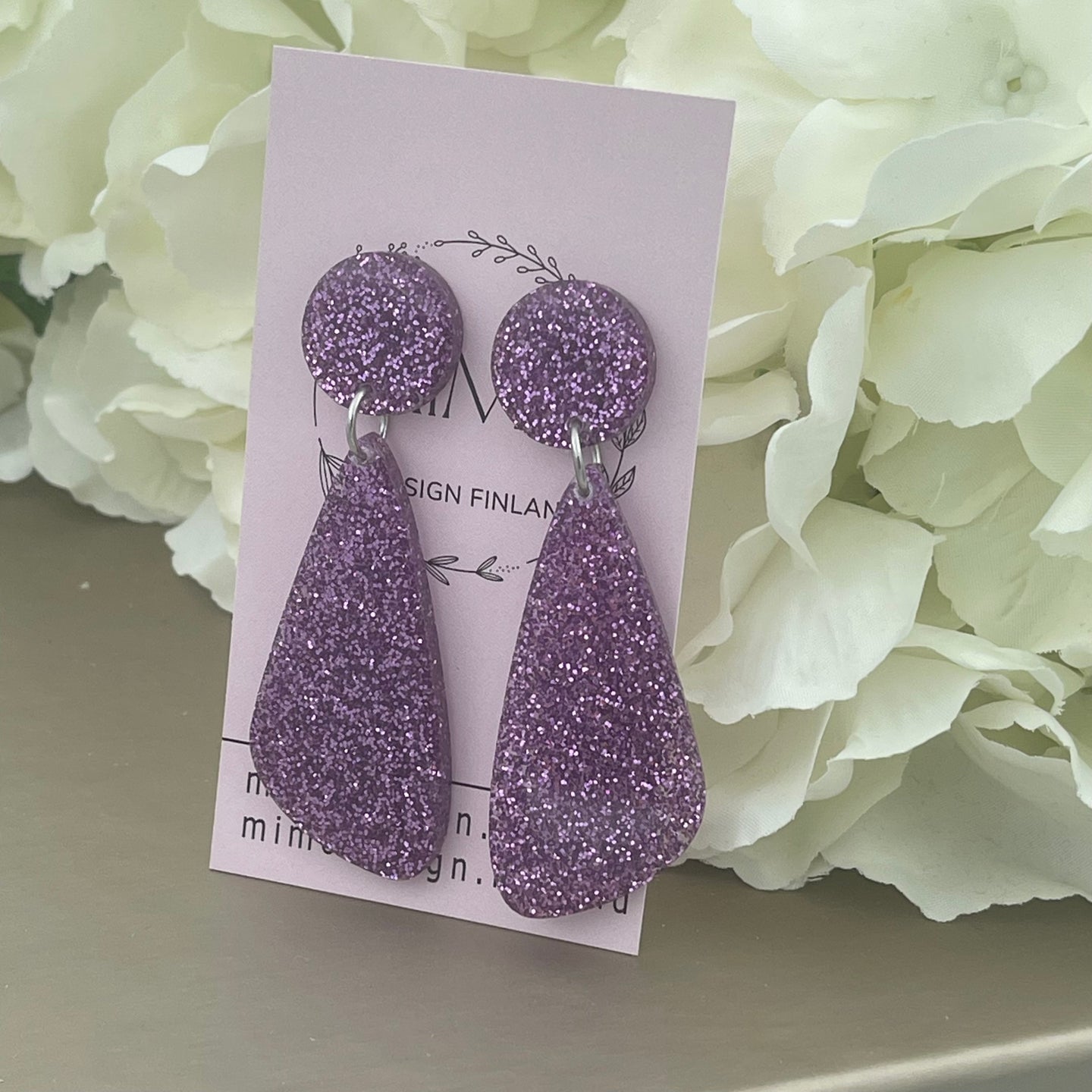 Suomessa käsintehdyt korvakorut glitteriakryylistä välkehtivät valossa ihanasti. Todella kevyet käytössä. Värivaihtoehtoja löytyy useita, joten jokaista asukokonaisuutta ja tilaisuutta täydentävä korupari löytyy varmasti. Tämä koru on lilan värinen.